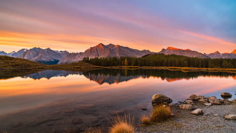 vibrant sunset over a tranquil alpine lake with mountain reflections