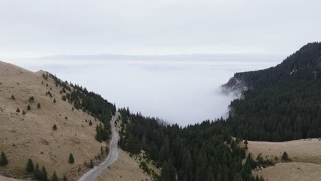 Flying-Towards-Foggy-Valley-Over-mountain-Road-In-Heart-Of-Bucegi-Mountains,-Romania