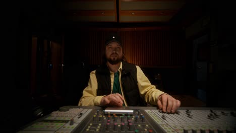 man working on a mixing console in a recording studio