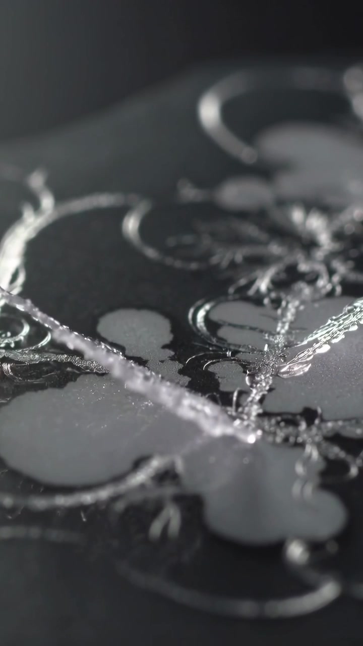 Vertical video: Shifting focus revealing growing feather crystal on studio decor panel with beads