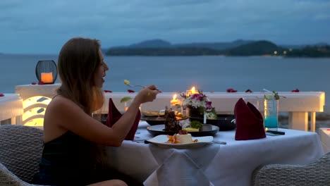 happy woman in elegant evening gown have romantic dinner with candles at night