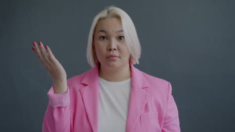 woman in pink blazer with questioning expression