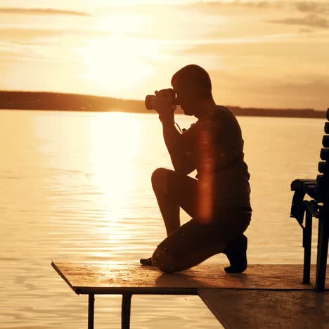 photographer taking picture of landscape during sunset. silhouette of people swimming in the river at sunset