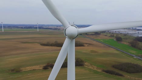 close-up drone shot of a moving turbine of an electric windmill - drone moving backwards and upwards