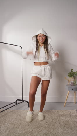 vertical pov video of female social media influencer producing user generated content in studio modelling a variety of fashion outfits shot in real time 11