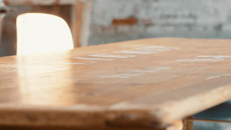 Placing-essentials-on-a-wooden-desk,-a-lamp-together-with-some-scissors-and-pencils