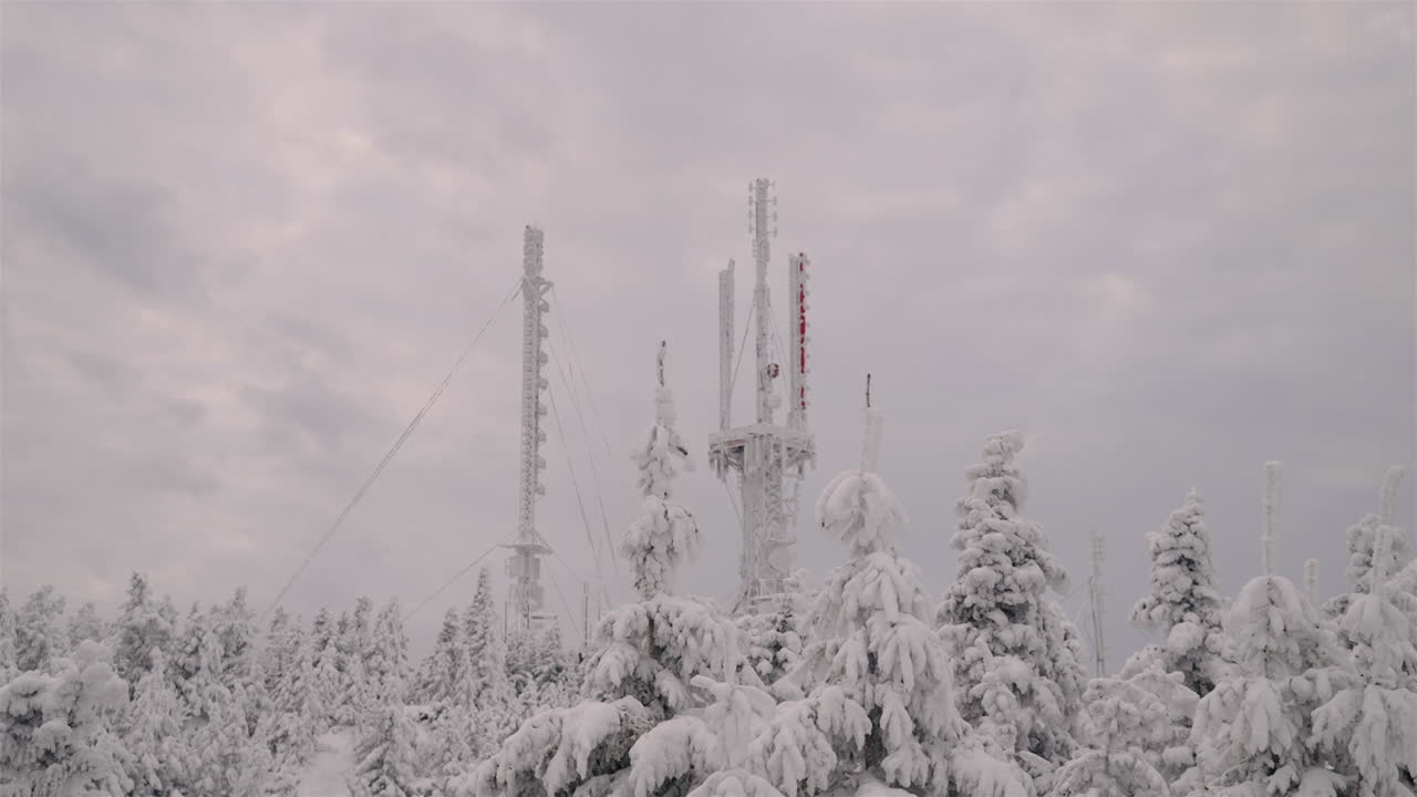 Antenna Towers With Coniferous Forest In Foreground Covered With Snow At Mont Orford Ski Resort During Winter Season In Quebec, Canada