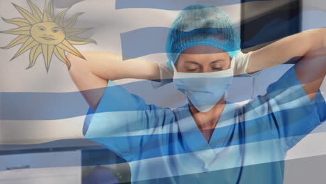animation of flag of uruguay waving over female surgeon in operating theatre