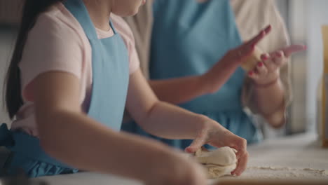 madre y su hija pequeña están cocinando panes dulces en la cocina de casa el domingo el niño está ayudando