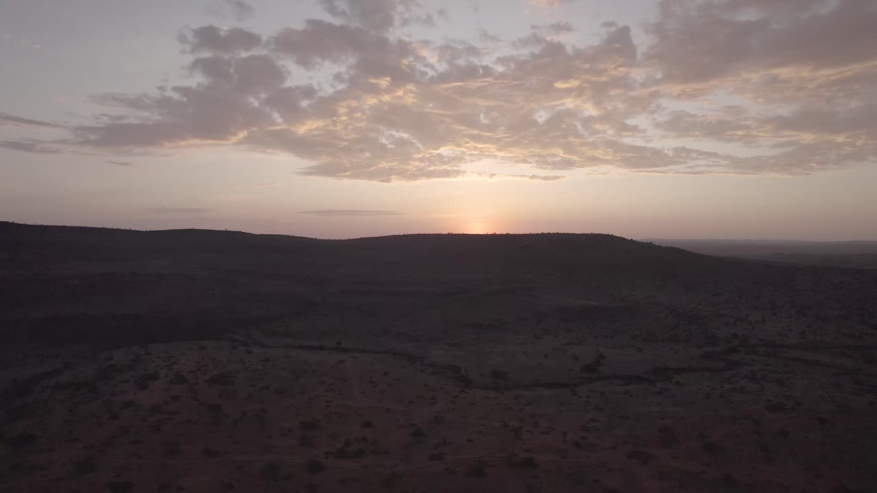 Aerial drone shot of Loisaba Conservancy's vast landscapes, showcasing wildlife, rivers, and rolling savannahs under golden sunlight