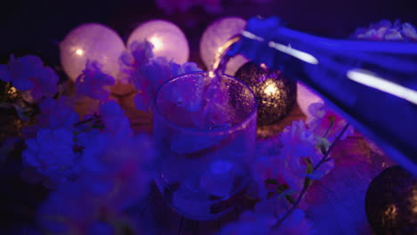 pouring tonic in a lowball glass with ice blocks and a slice of lemon for an alcohol beverage