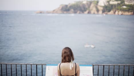 Young-girl-watches-with-admiration-the-amazing-seascape-of-the-Costa-Brava,-Catalonia,-Spain