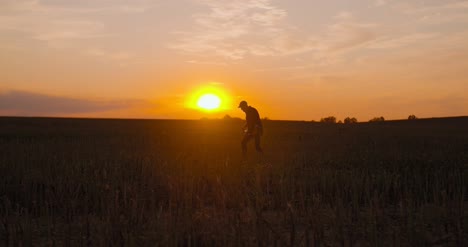 Drunken-Farmer-Drinking-Alcohol-On-Field-During-Sunset-1