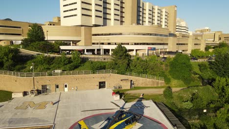 modern helicopter near university of michigan hospital, aerial ascend view