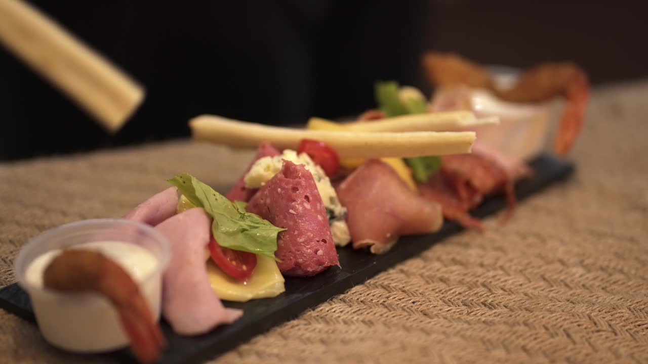 Close-up view of assorted charcuterie board with cold cuts and cheese on slate platter
