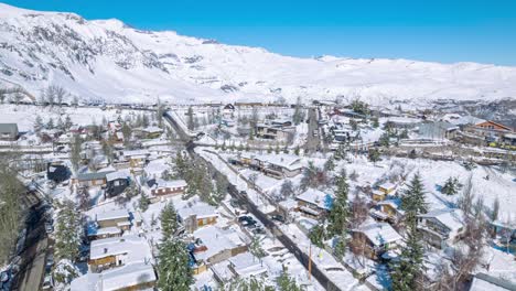 Hiperlapso-Aéreo-En-órbita-Con-Efecto-De-Paralaje-En-El-Pueblo-Montañoso-Completamente-Nevado-De-Farellones,-Montañas-Nevadas-Al-Fondo,-Chile