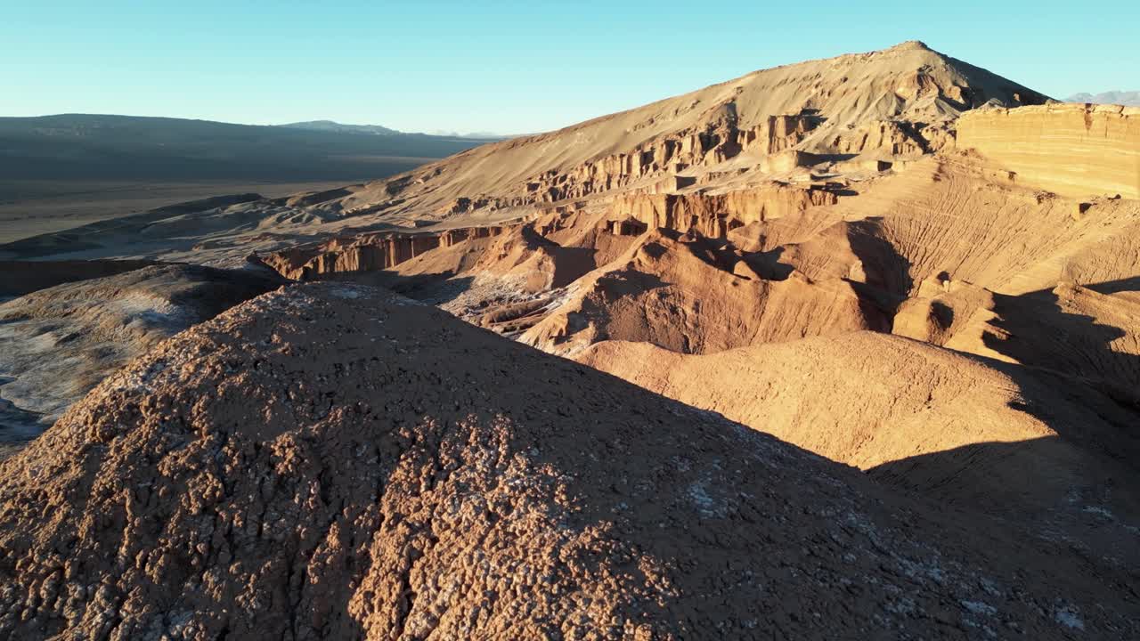 Sweeping drone perspective of Chile’s moon valley at twilight, showing textured rock formations and wide desert panoramas
