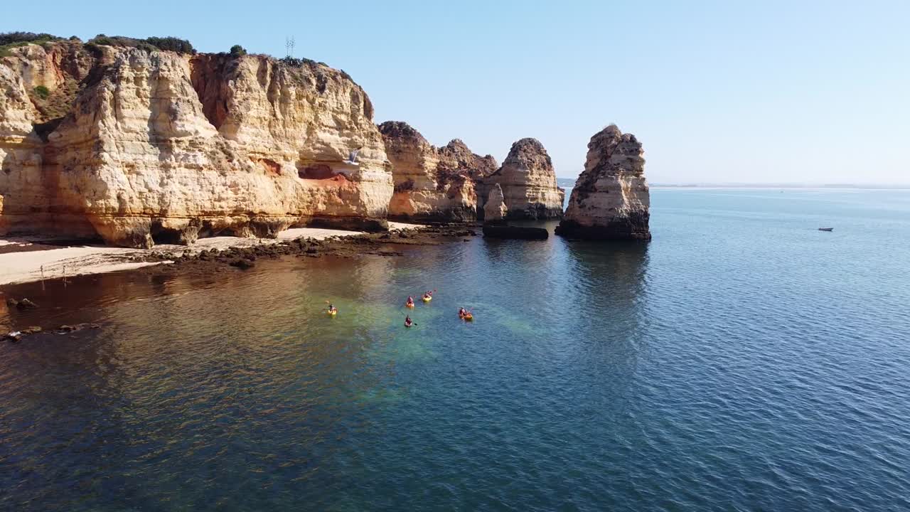 ponta da piedade, lagos, algarve - 카약 관광객과 황금 절벽이 있는 바위가 많은 해안선의 공중 무인 항공기 전망