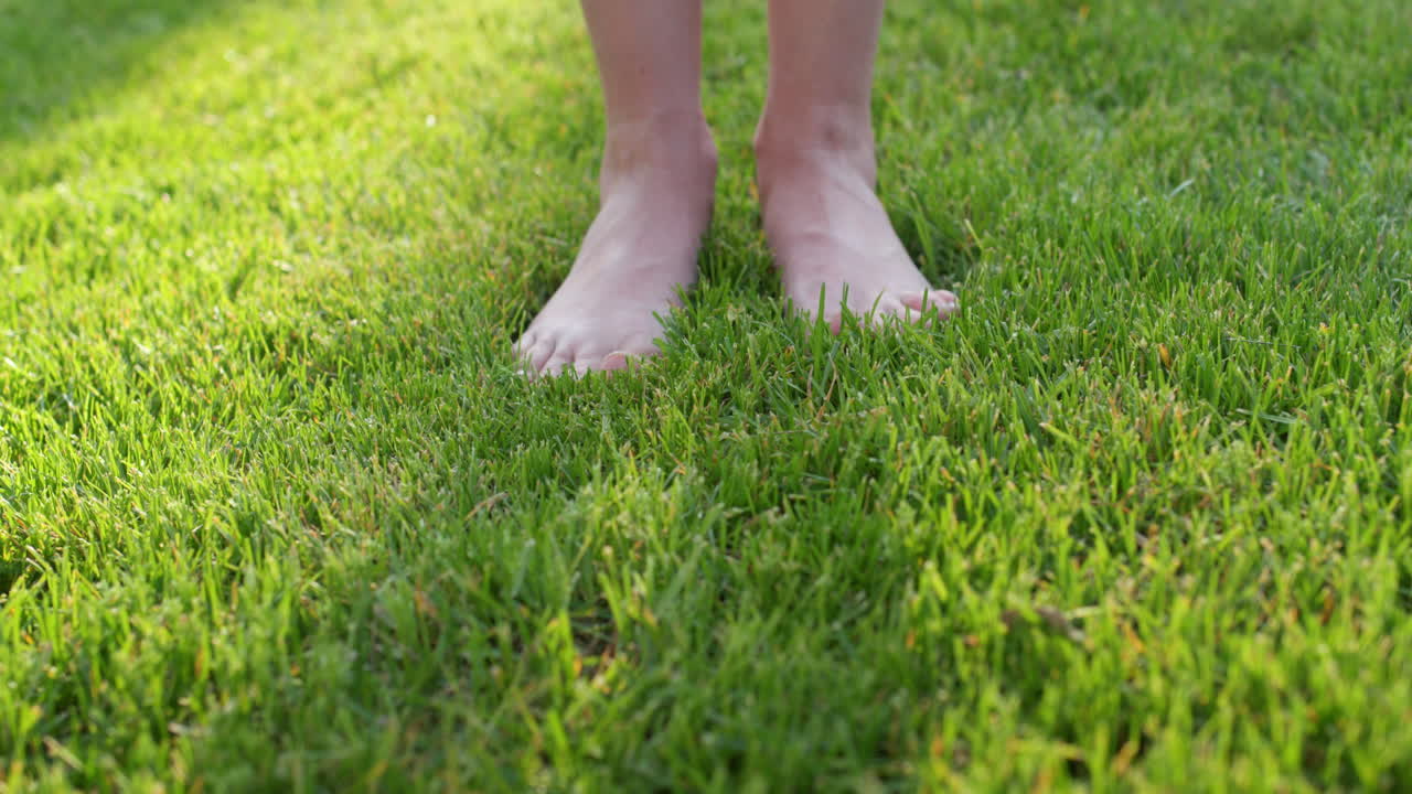 Women's feet barefoot in the gentle green grass
