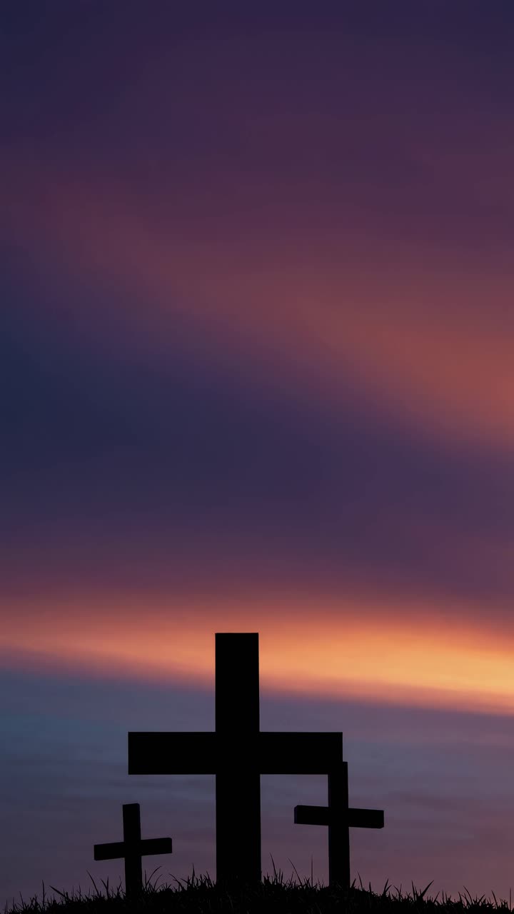 Silhouetted crosses against a vibrant sunset sky, captured from a low angle