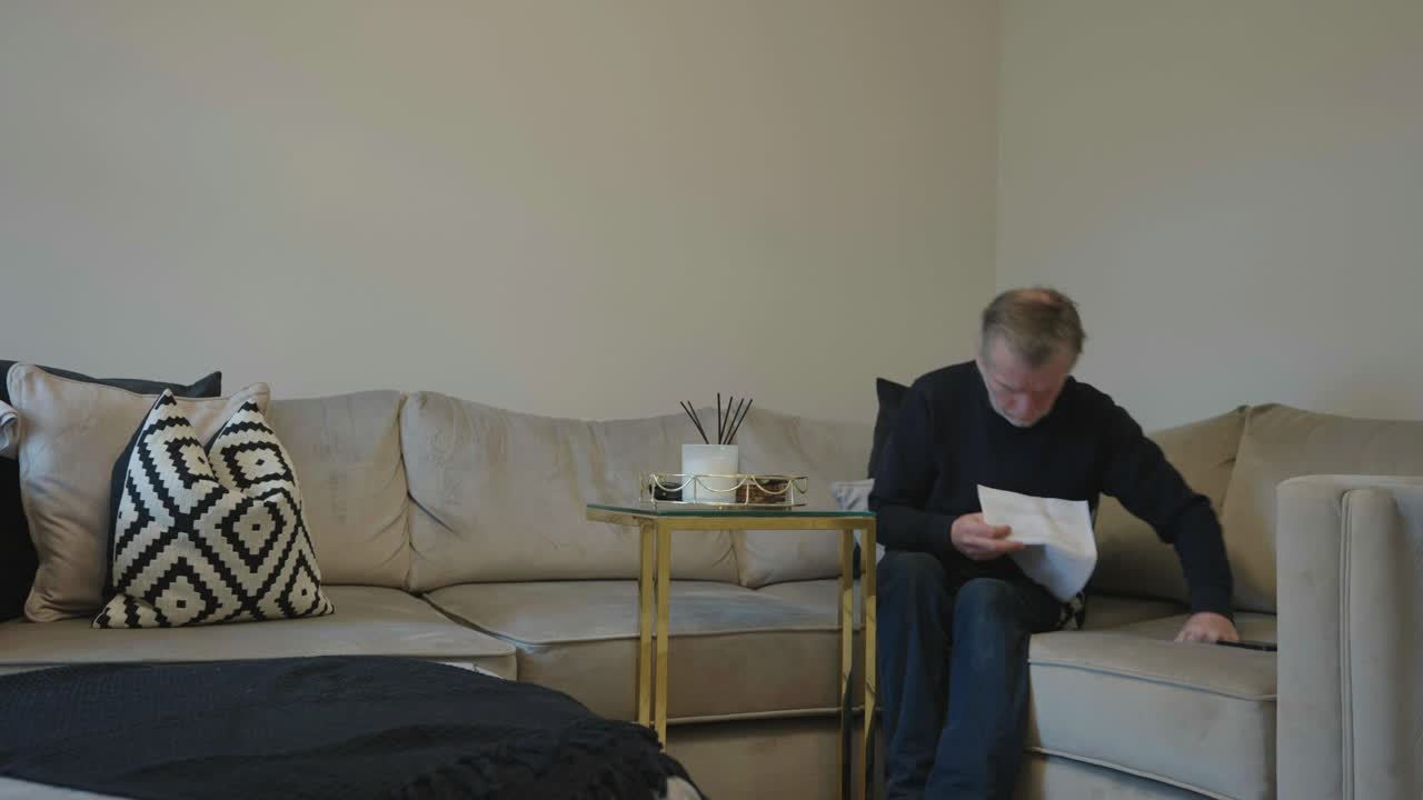 мужчина в возрасте 50 лет читает важное письмо и думает.