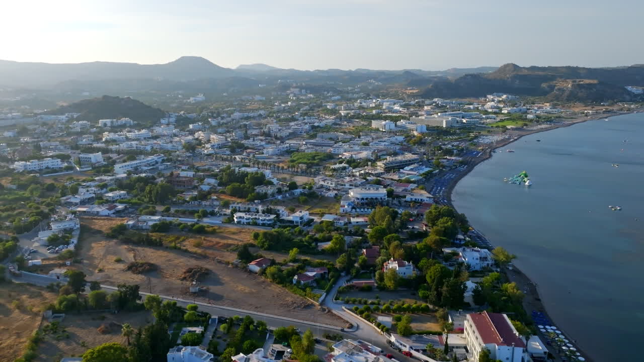Aerial tracking shot of the seafront of Faliraki town, golden hour in Rhodes