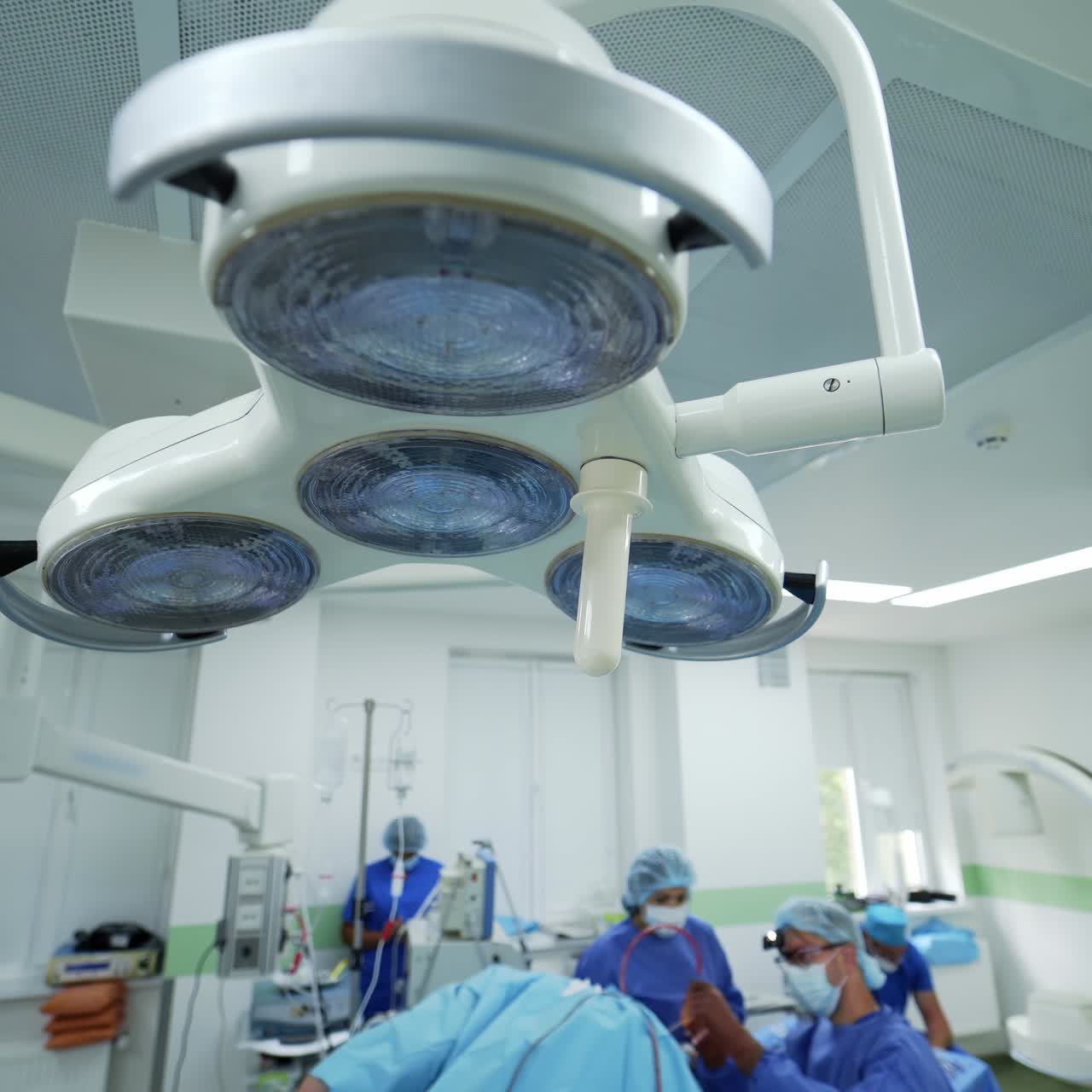 Panoramic view of surgical room. Large medical lamp in the operating room. Surgeons perform an operation in modern clinic