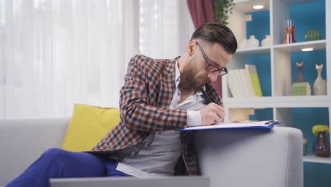 Ein-Mann,-Der-Zu-Hause-Einen-Laptop-Benutzt,-Arbeitet-Und-Ist-Gestresst-Und-Besorgt-über-Seine-Arbeit.