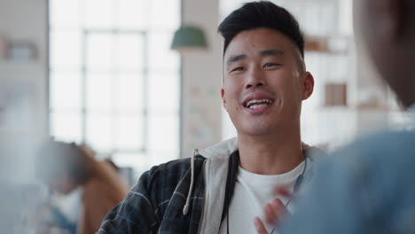 attractive young asian man training colleague pointing at screen sharing ideas enjoying creative teamwork in workplace