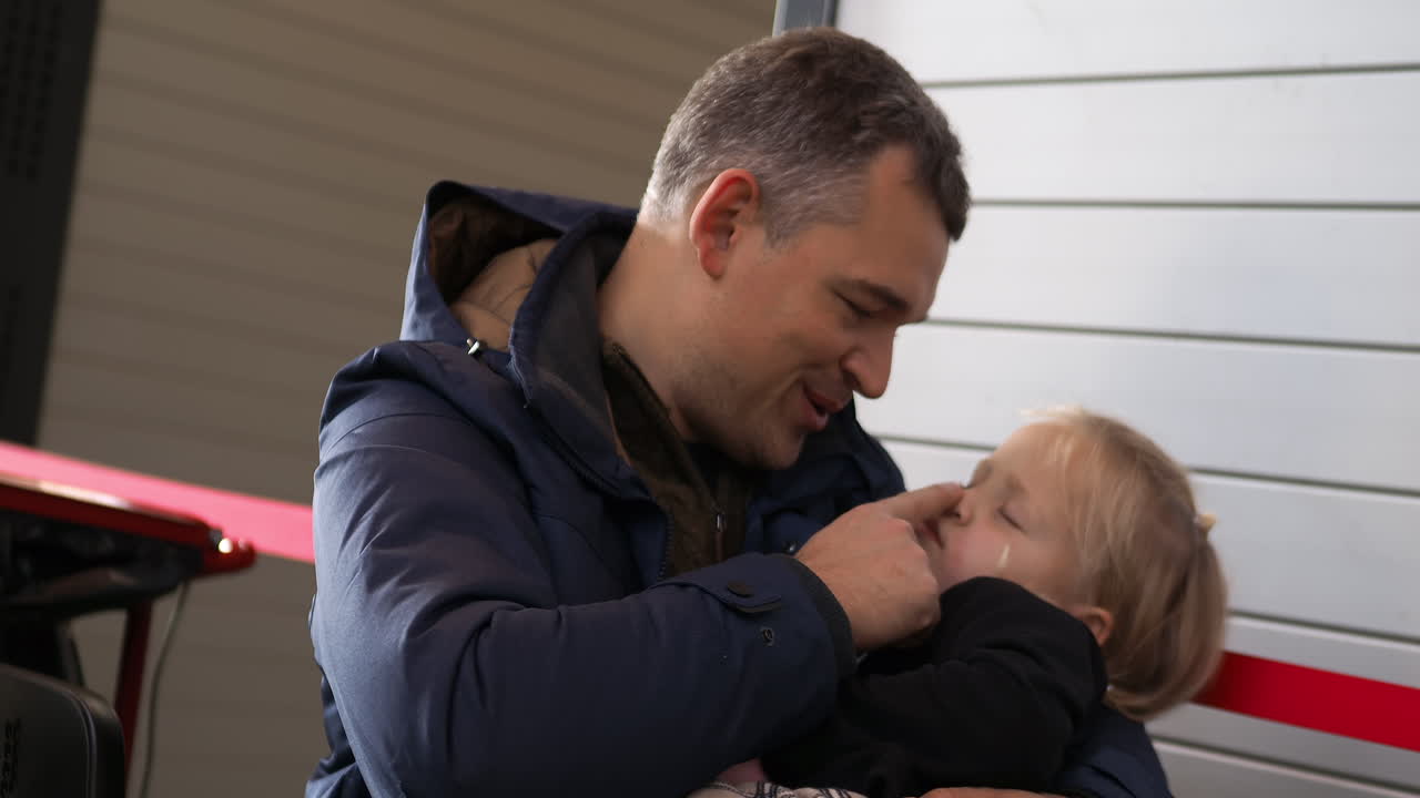 padre y pequeña hija durmiente esperando en la estación