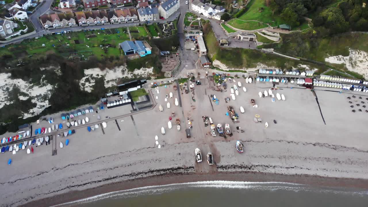 4K Aerial shot descending above the beach and exposing the beautiful town of Beer in Devon England