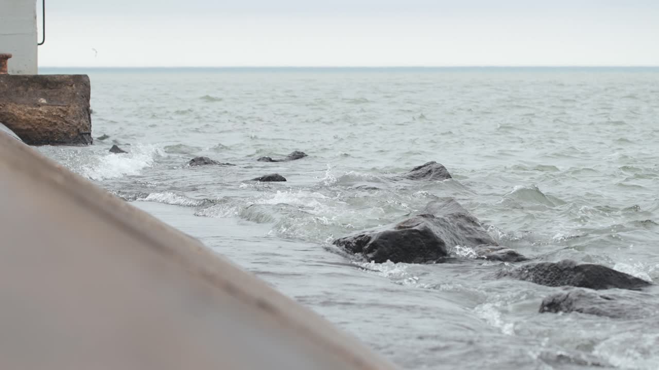 등대로 튀는 바위의 슬로우 모션 측면 보기