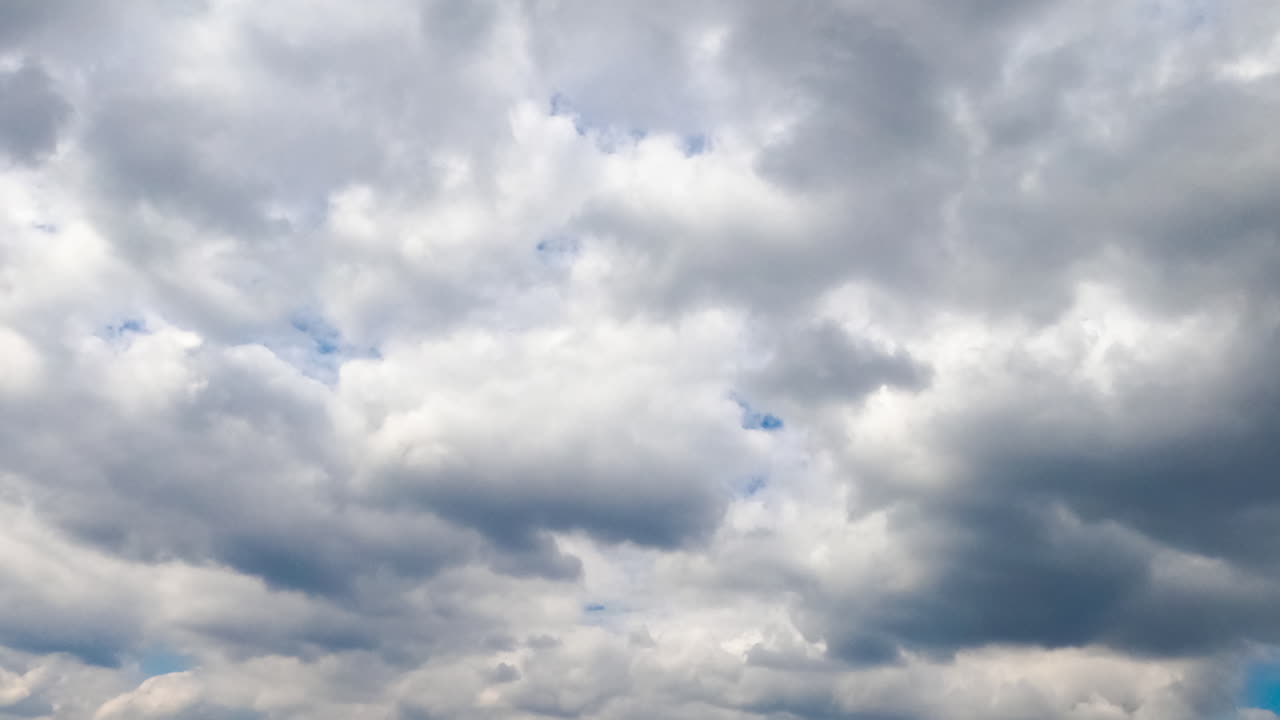Moving grey cloudscape in the atmosphere. Cumulus clouds gathering before the rain. Low angle view. Timelapse.