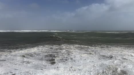 large ocean wave swells come ashore after storm on wild sea coast