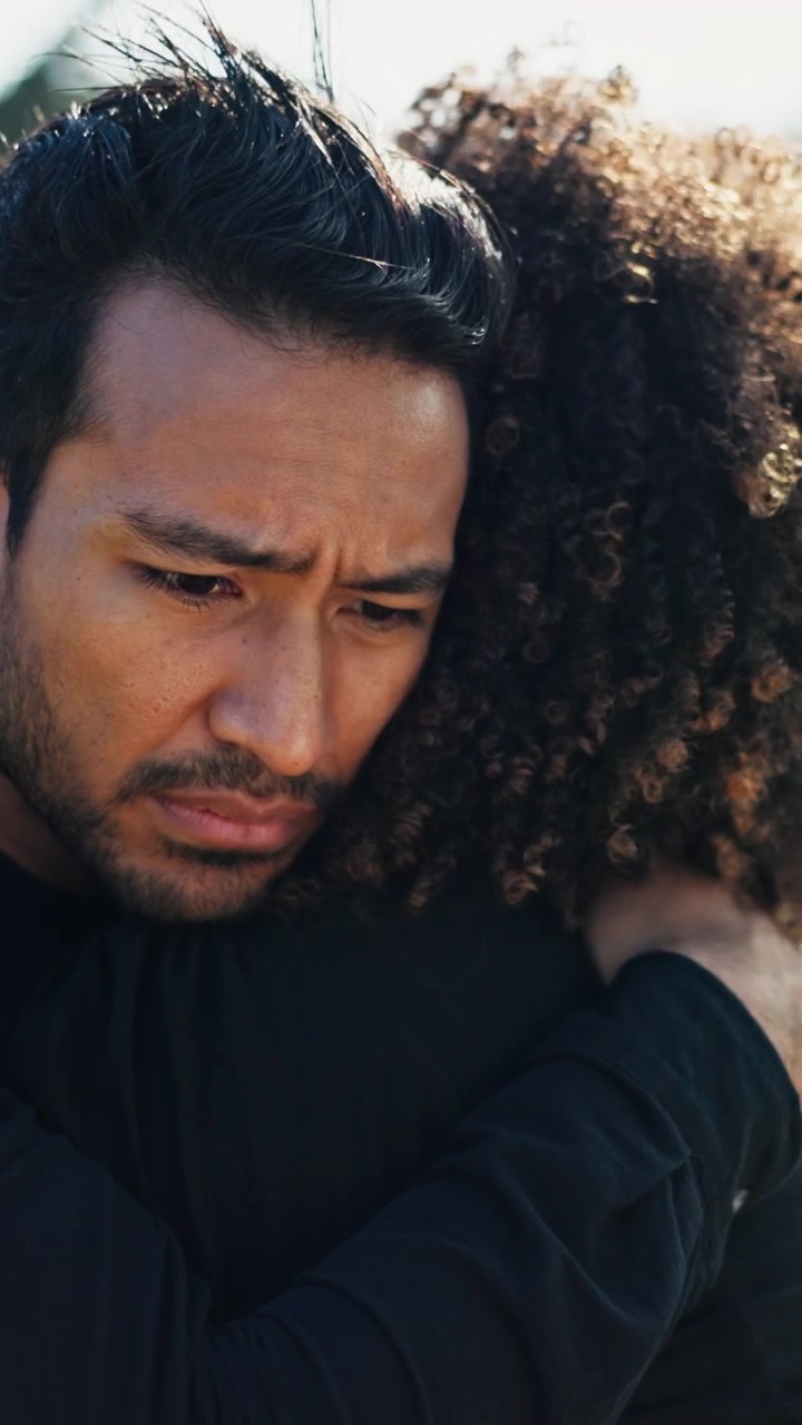 Grieving Man Embracing Woman at Funeral Service