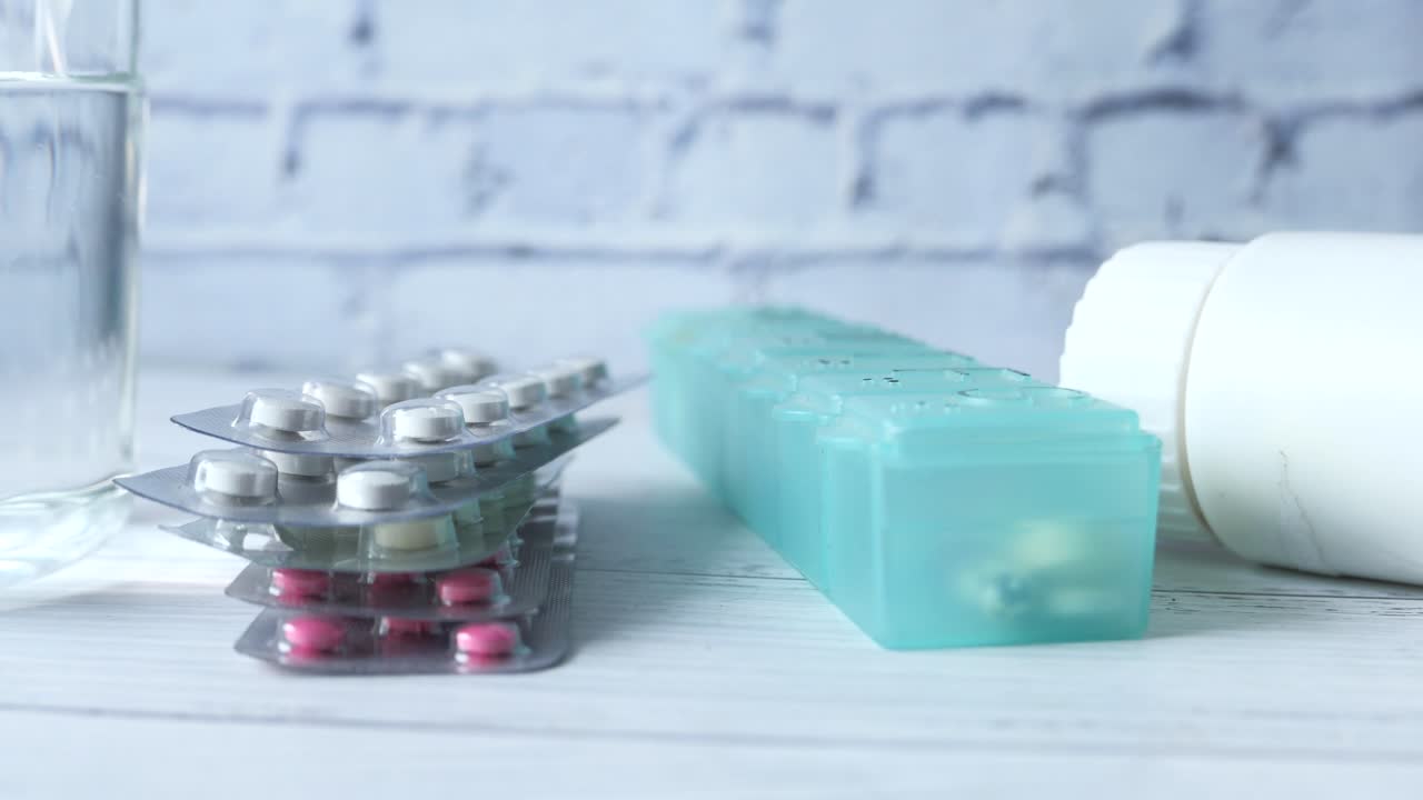 medicamento y organizador de pastillas en una mesa de madera