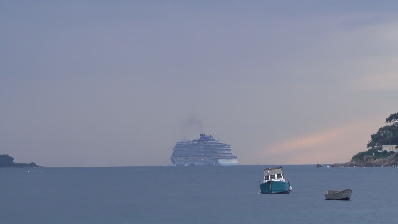 Boats moving on the sea with buildings and trees on the background