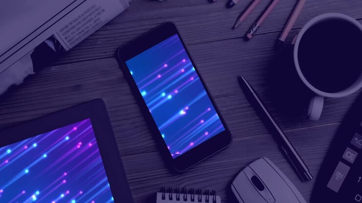 Animation of technological devices with light trails on screen on desk