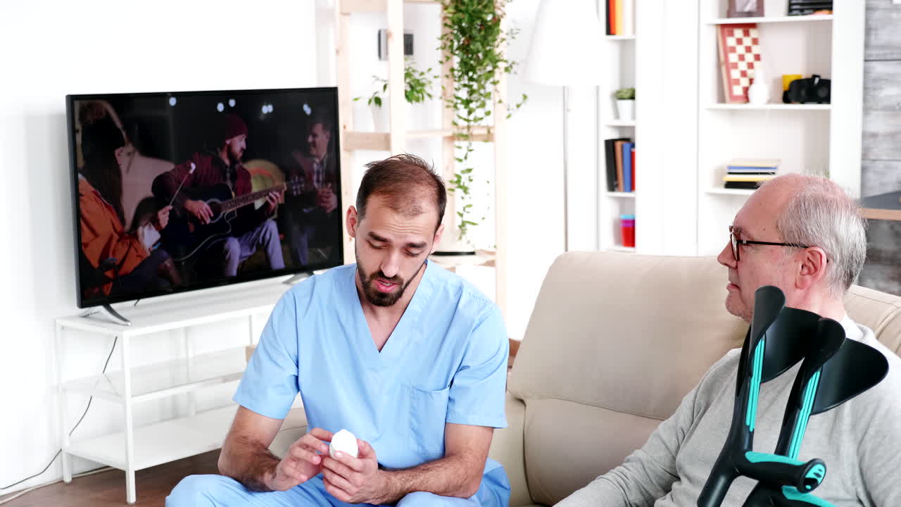 Young doctor helping old man with his pills