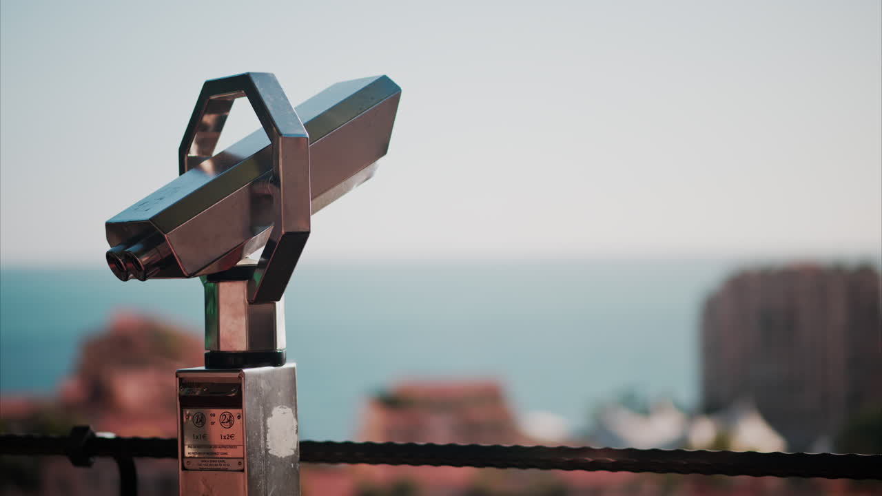 A coin operated binocular with a blurry view of the sea