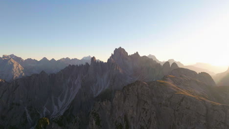 Glühende-Sonnenstrahlen-über-Südtirol-Tre-Cime-Extreme-Berglandschaft-Luftbild-Fliegend-Vorwärts