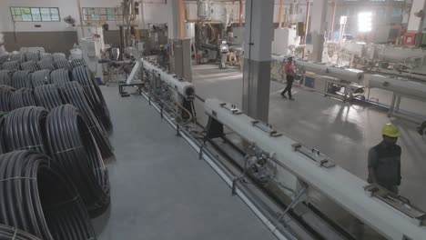 indoor view of pakistani pvc pipe making factory in karachi with workers working.