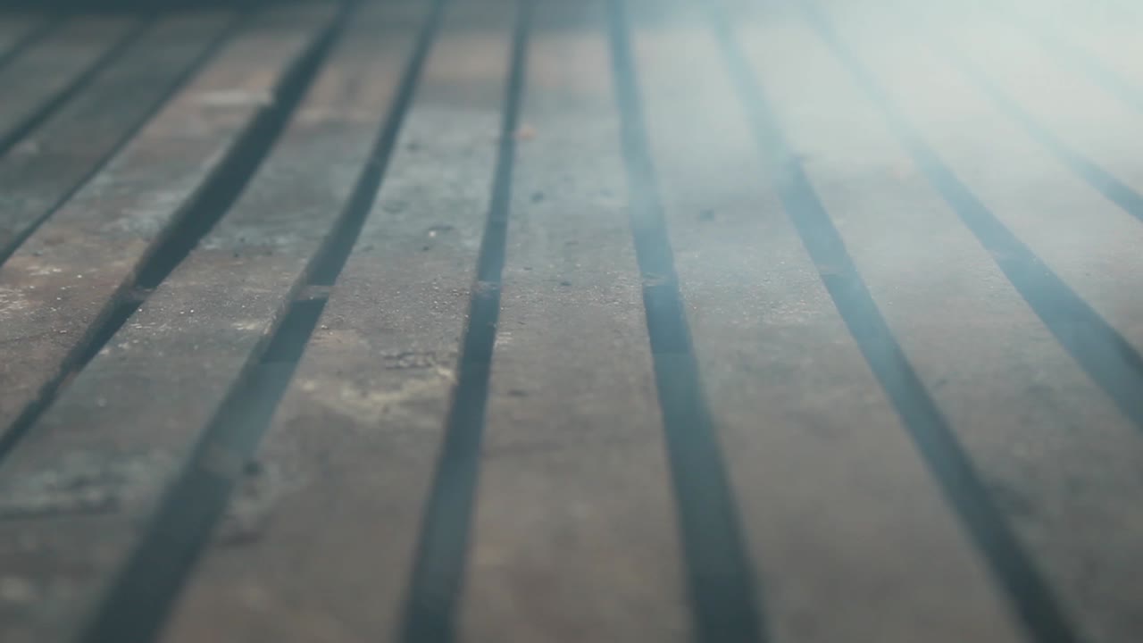 Close up of rustic iron grill with smoke, no food