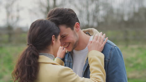 una pareja transexual amorosa abrazándose en un paseo por el campo en otoño o invierno