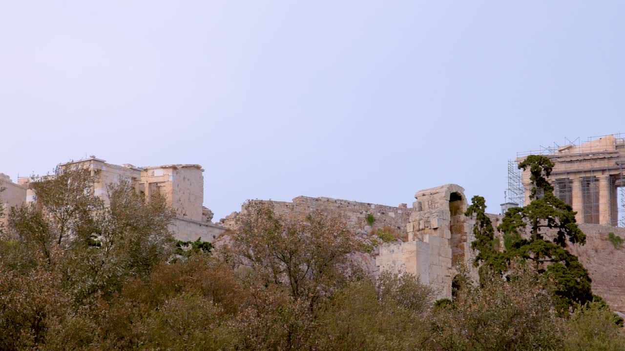 la acrópolis emerge de detrás de los árboles verdes y exuberantes