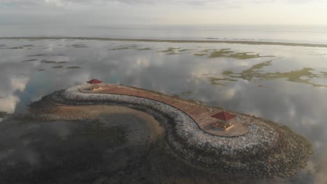 Wide-shot-of-famous-Sanur-beach-huts-at-Bali-during-calm-morning,-aerial