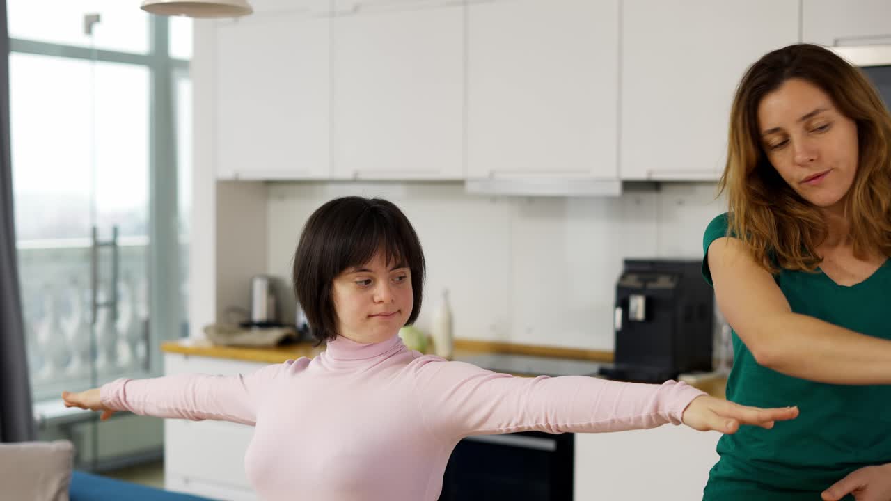 Girl with down syndrome practicing yoga position at home with help of teacher