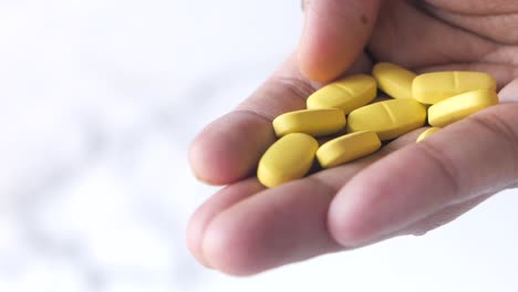 hand holding yellow pills