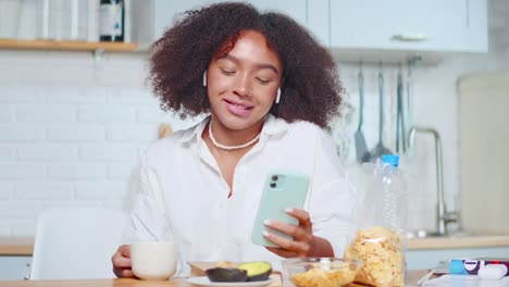 confident young african american woman talking by video call during breakfast