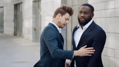 Businessmen-reading-bad-news-on-screen-in-city.-Colleagues-using-pad-at-street